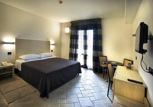 Pratola Peligna宫欧娜别墅酒店的一间卧室配有一张床、一张书桌和一台电视