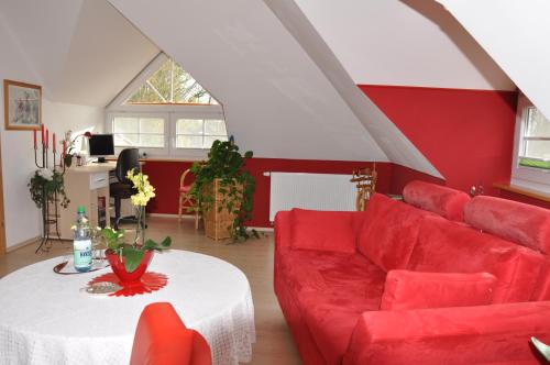 巴德茨维什安Ferienwohnung an der Allee的客厅配有红色的沙发和桌子