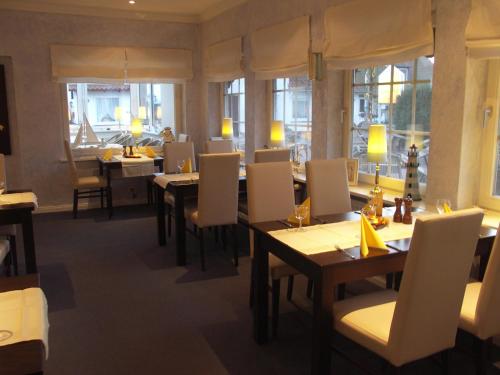 霍瓦赫特霍赫瓦赫特霍夫旅馆的餐厅设有桌子和白色的椅子以及窗户。