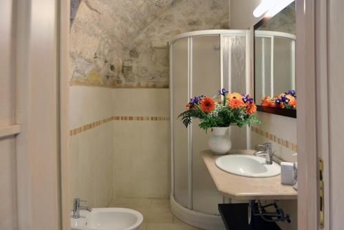 拉古萨瑞莱斯席米拉住宿加早餐乡村民宿的浴室设有2个水槽、镜子和鲜花