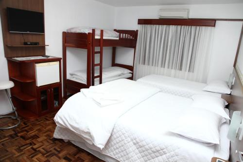 特雷齐蒂利亚斯Hospedaria Gãstehaus Enzian的一间卧室配有两张双层床和电视