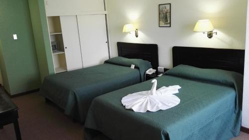 圣何塞纽沃马拉家托旅馆酒店的酒店客房设有两张带花卉的床。