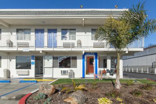 海沃德Motel 6 Hayward, CA- East Bay的前面有棕榈树的建筑