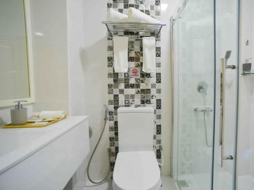 胡鲁马累呼尔胡维拉海滩椰子树酒店的白色的浴室设有卫生间和淋浴。