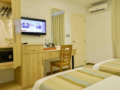 胡鲁马累呼尔胡维拉海滩椰子树酒店的酒店客房设有两张床和电视。