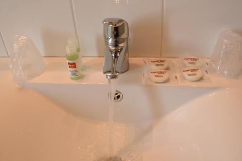 维耶尔宗欧陆式酒店的浴室水槽从水龙头流出水