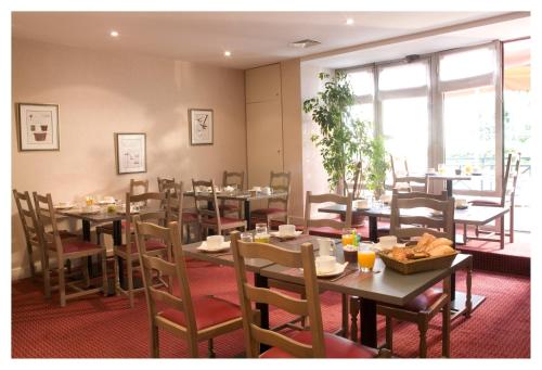 索恩河畔自由城基里亚德维勒弗兰切苏尔萨那酒店的用餐室设有桌椅和窗户。