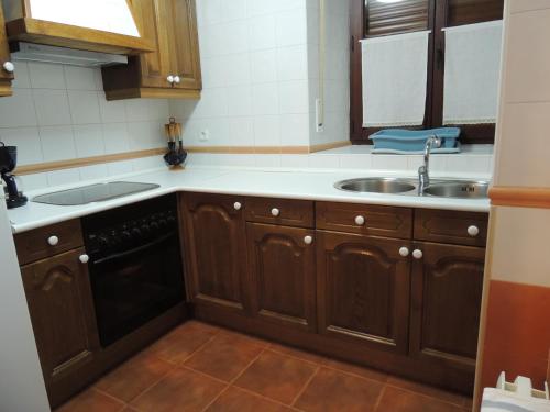 TarilonteEl Encinar的一个带木制橱柜和水槽的厨房