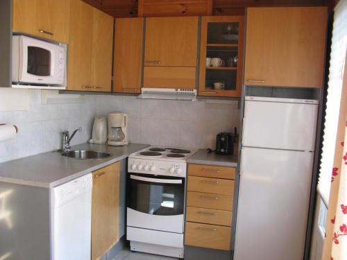 科林基拉Koli Country Club的小厨房配有白色家电和木制橱柜。