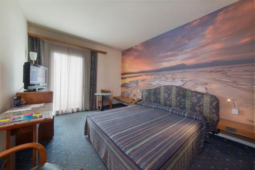 西尔米奥奈卡图洛酒店的配有一张床和一台平面电视的酒店客房