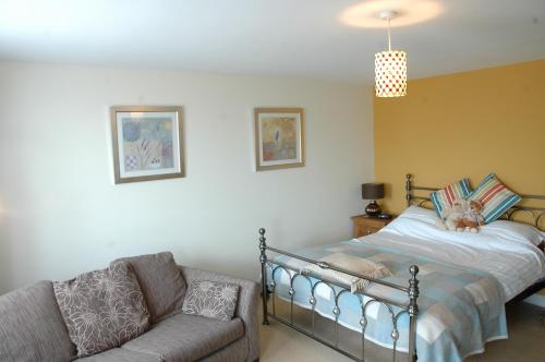 莱伯恩王后之首酒店的一间卧室配有一张床和一张沙发