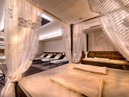 瑟弗浩斯Hotel Universo的一间设有四张带窗帘的床的房间