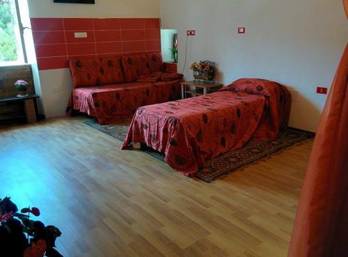 CelicoLa Meridiana Bed & Bike的一间卧室配有红色的床和一张沙发