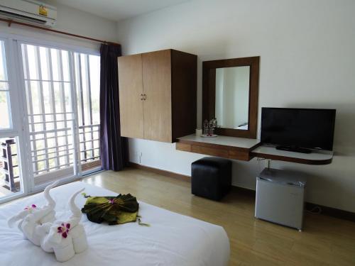 南邦南邦SR酒店的一间卧室配有一张带镜子的床和一台电视