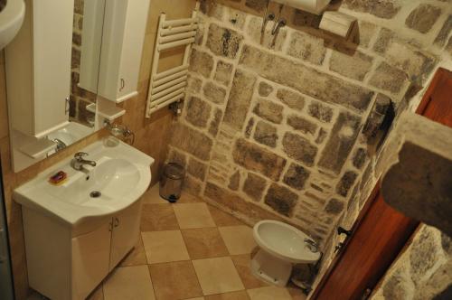 科托尔老城青年旅舍的一间带水槽和石墙的浴室