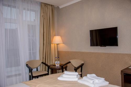 泽列诺格拉茨克伊丽莎酒店的酒店客房设有一张床和墙上的电视