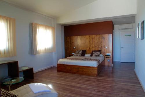 代尔特布雷马斯普拉德斯酒店的一间卧室配有一张带木制床头板的床