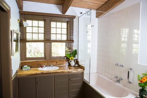 沃伯顿莨山住宿加早餐旅馆的一间带水槽和浴缸的浴室以及窗户。