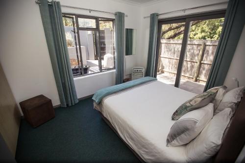豪特湾Chapman's Peak Bed and Breakfast的一间卧室设有一张床和一个大窗户