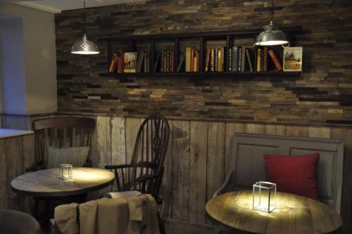 沃丁顿Higher Buck Inn的餐厅设有两张桌子和椅子,备有书籍