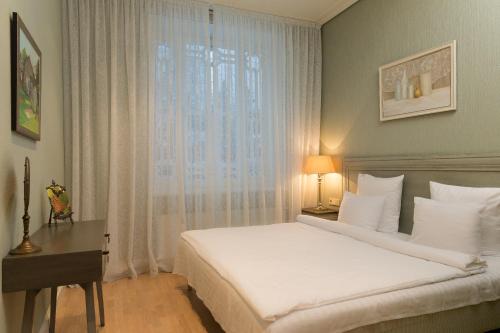 尤尔马拉木屋别墅公寓的一间卧室配有一张床、一张书桌和一个窗户。