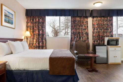 布罗克维尔布罗克维尔戴斯酒店的配有一张床和一把椅子的酒店客房