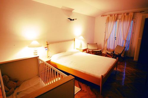 马林斯卡Holiday Home Valica的一间卧室配有一张床和一张婴儿床