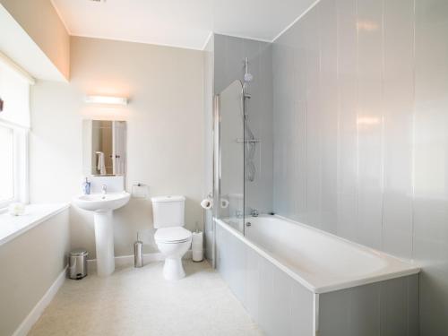 皮特洛赫里Ballinluig Rooms & Suites的白色的浴室设有浴缸、卫生间和水槽。