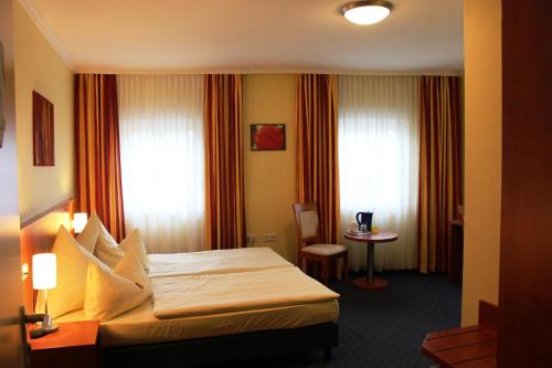 吕德斯海姆吕德斯海姆公园酒店的酒店客房配有一张床铺和一张桌子。