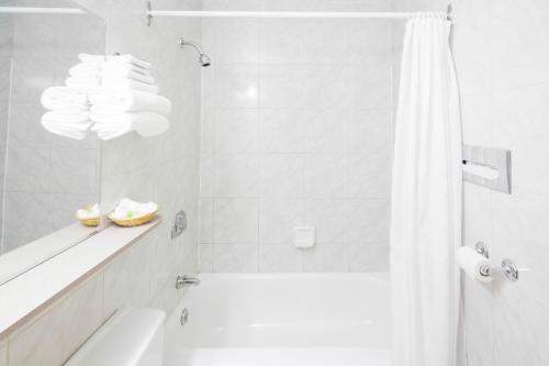 拉图克Hôtel Marineau Centre的白色的浴室设有浴缸和淋浴。