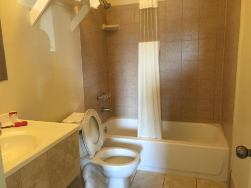 杰克逊维尔海岸汽车旅馆的浴室配有卫生间、浴缸和水槽。
