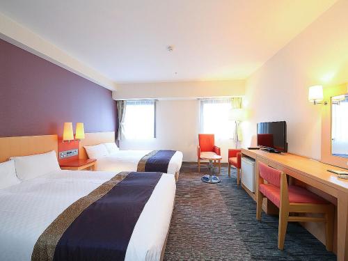 新泻新泻聚乐经济型酒店的酒店客房配有两张床和一张书桌