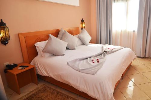 阿加迪尔大西洋棕榈滩公寓式酒店的一间卧室配有带白色床单和枕头的床。