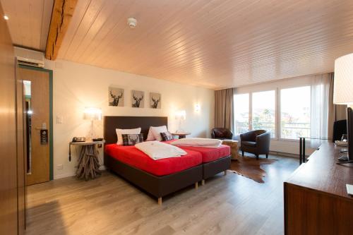 黑里绍兰德桑蒂斯海利桑酒店的一间卧室,卧室内设有一张红色的大床