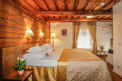 维胡拉维胡拉庄园乡村俱乐部&SPA的一间卧室配有一张带木墙的大床