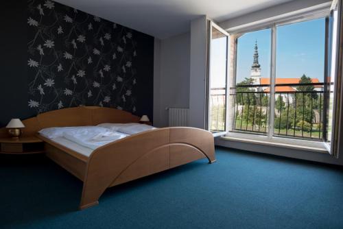 瓦赫河畔新梅斯托戴安娜酒店的一间卧室设有一张床和一个大窗户