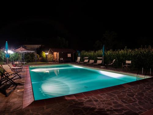 普拉托韦基奥Belvilla by OYO Villa Lonanno的游泳池在晚上点亮
