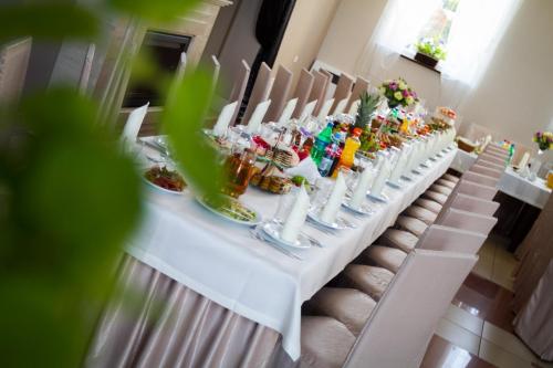 ZwoleńVanilla House的一张长长的白色桌子,上面有食物和饮料