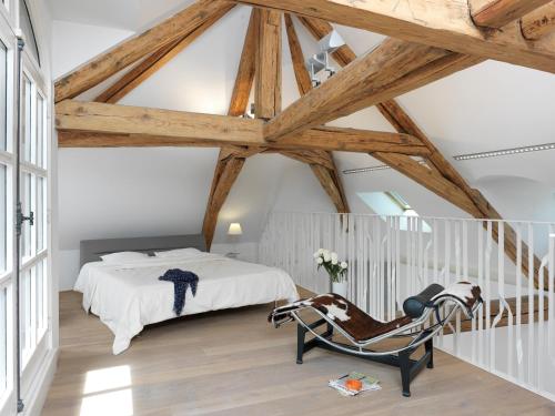 安锡Le Loft d'Annecy - Vision Luxe的一间卧室配有一张床和一把摇椅
