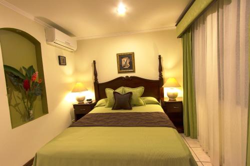 奥罗蒂纳Hotel Iguana Verde的一间卧室配有一张带绿床单和枕头的床。