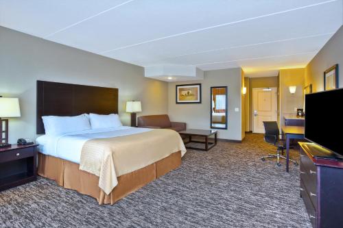 绿湾Holiday Inn & Suites Green Bay Stadium, an IHG Hotel的配有一张床和一台平面电视的酒店客房
