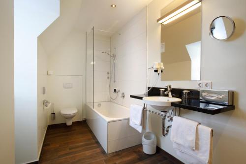纽伦堡Hotel am Jakobsmarkt的一间带水槽、卫生间和镜子的浴室