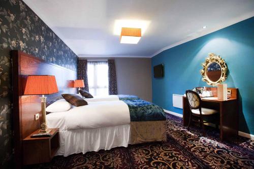爱丁堡薇希尔斯波恩白女士酒店的酒店客房设有一张大床和一张书桌。