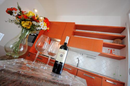 加利波利Baia Verde Apartments的一瓶葡萄酒,坐在柜台上,配两杯