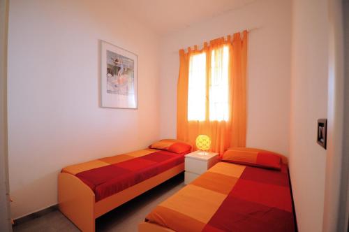 加利波利Baia Verde Apartments的一间卧室设有两张床和窗户。
