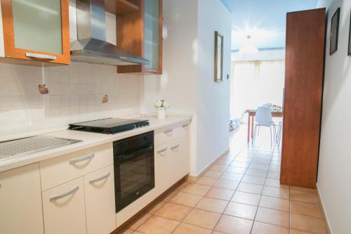 皮内托Poseidon Pineto Vacanza的厨房配有白色橱柜和瓷砖地板。