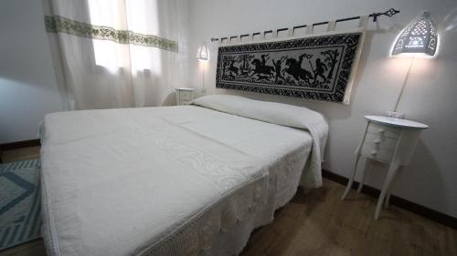 SorgonoAffittacamere Sa Mariola的一间小卧室,配有白色的床和一张桌子
