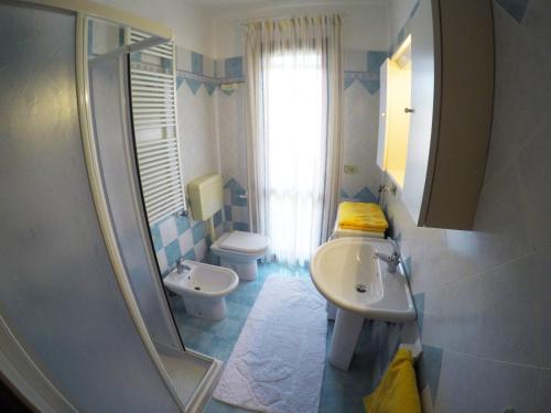 卡奥莱Residence Pineta - Agenzia Cocal的一间带水槽、卫生间和镜子的浴室