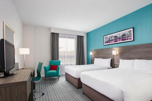 普里茅斯Leonardo Hotel Plymouth的酒店客房设有两张床和电视。