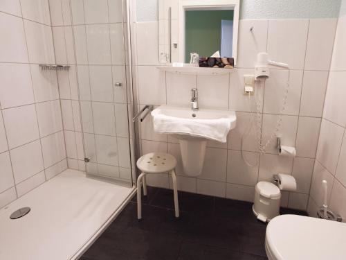BehringenHotel Zum Herrenhaus的白色的浴室设有水槽和淋浴。